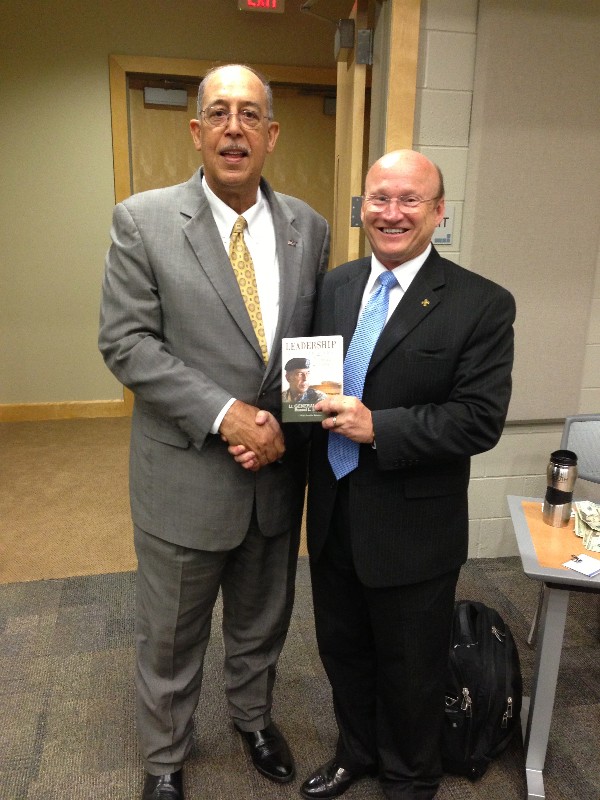 Lt. Gen. Russel L. Honoré, USA (Ret.) (l), guest speaker at the chapter's April Military IT Day, presents a signed copy of his book “Leadership in the New Normal” to Mike Waters, chapter executive vice president.